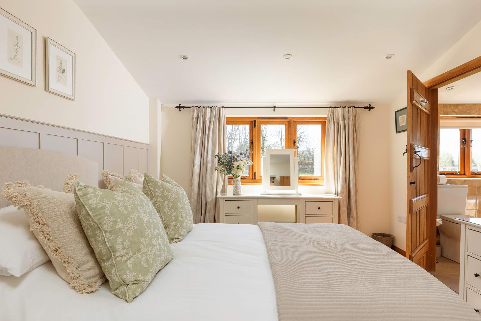 Bedroom 1 is a peaceful retreat with calming tones and tasteful floral touches.