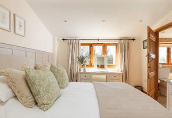 Bedroom 1 is a peaceful retreat with calming tones and tasteful floral touches.