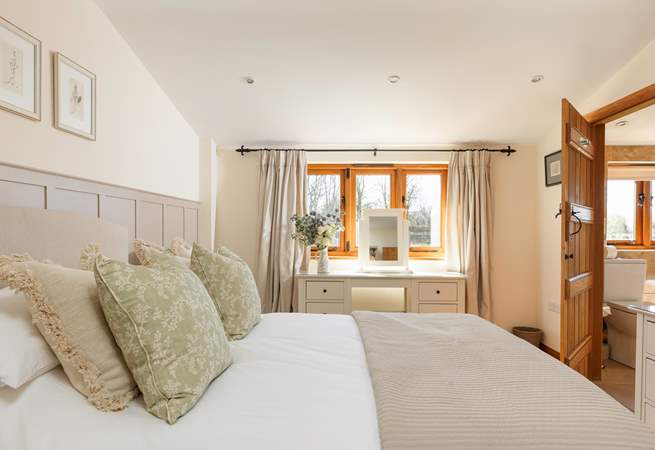 Bedroom 1 is a peaceful retreat with calming tones and tasteful floral touches.