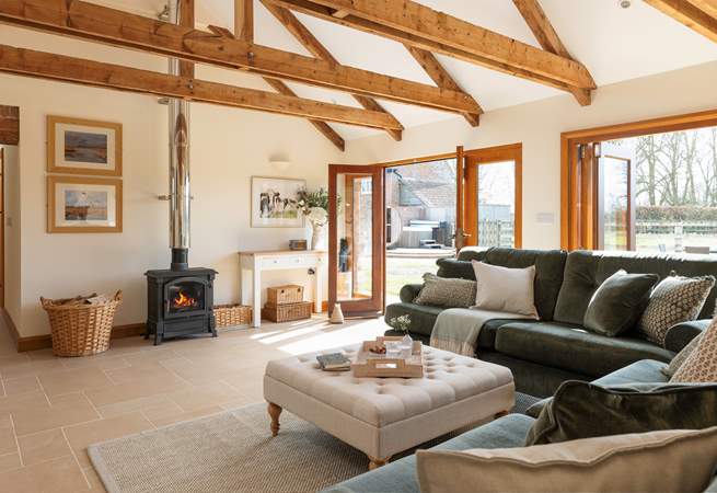 There is a high-ceiling open plan living space, with wonderful bi-fold doors that open up the side of the barn to the garden.