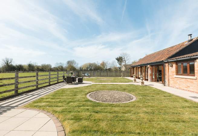 The fully enclosed garden has open views across the fields, and a hot tub and sauna in a private corner.