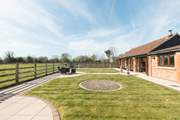 The fully enclosed garden has open views across the fields, and a hot tub and sauna in a private corner.