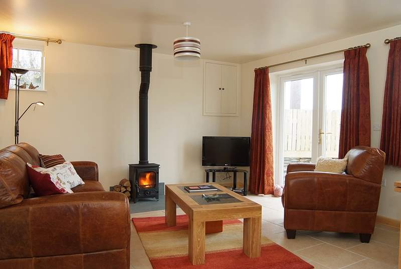 Wheel Barn has a comfortable open plan living-room with a wood-burner and French doors out to an enclosed garden.