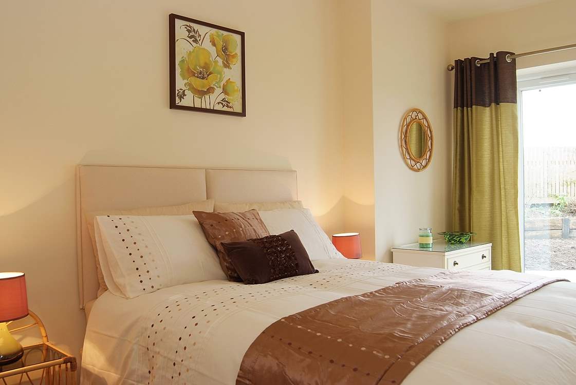 The bedroom has patio doors out to the garden.