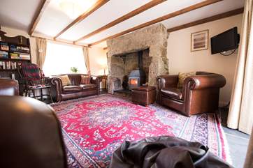 Leather furniture flanks the wood-burner.