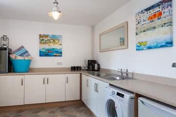The utility-room which leads out to the lovely large patio area, is very useful with extra tea and coffee making facilities.