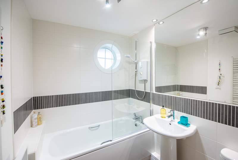 The lovely family bathroom with an extra large mirror and luxurious bathing essentials provided.