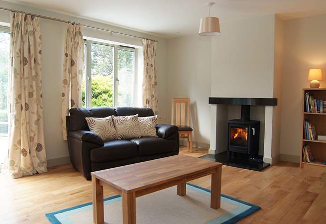 The open plan living-room is very spacious, with a wood-burner in the sitting-area.