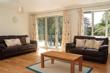 Bi-fold doors open up from the sitting-area to the patio that runs the length of the house.