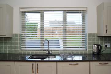 The kitchen looks out over the front garden and parking-area, all securely enclosed.