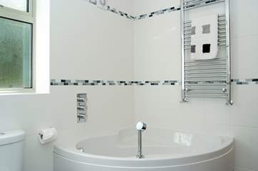 The ground floor en suite bathroom has a corner bath as well as the walk-in shower.