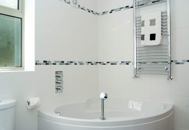 The ground floor en suite bathroom has a corner bath as well as the walk-in shower.
