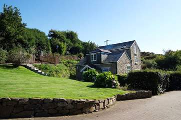 The driveway then winds down to the spacious parking-area near the house.