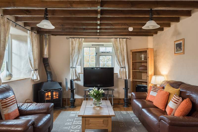 The sitting-area features a surround sound television and a welcoming wood-burner.
