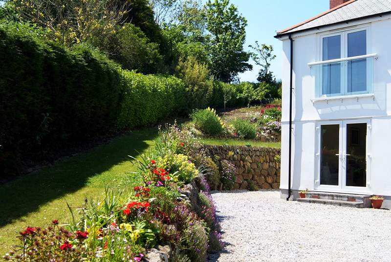 The garden is bordered by beautifully planted colourful flowerbeds.