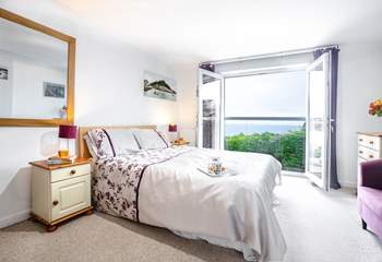 Bedroom 2 has a king-size bed, and double glass doors with a Juliet balcony overlooking the bay.