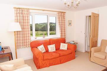 The light-filled sitting-room, with wood-burner for out-of-season breaks, looks out over the garden and open countryside.