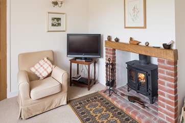 The sitting-room has comfortable sofas and looks out over the garden and open countryside.