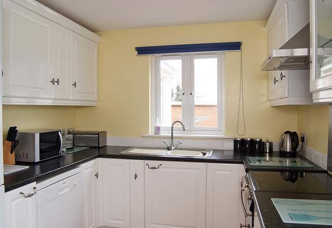 The kitchen is next to the sitting/dining-room and also looks out onto the back garden.