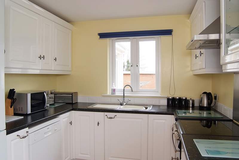 The kitchen is next to the sitting/dining-room and also looks out onto the back garden.