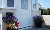 In summer there are colourful pots of flowers either side of the front door. - Thumbnail Image