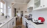 The galley-style kitchen is extremely well-equipped and leads through into the main living-area. - Thumbnail Image