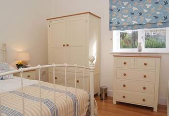 The bedroom has a king-size bed and is beautifully decorated with plenty of storage.