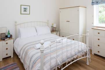 The bedroom has a king-size bed and enjoys the morning sunshine.