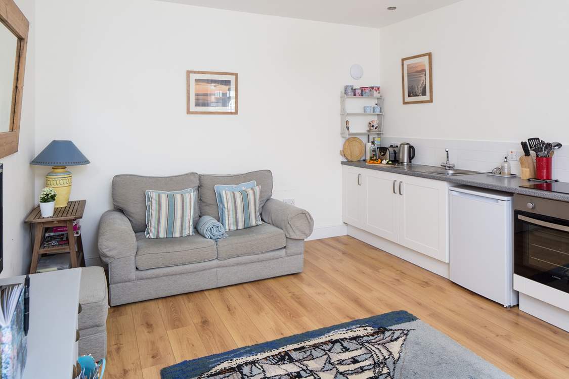 The open plan design of this cottage has plenty of comfortable space, the kitchen area is cleverly fitted along one wall.