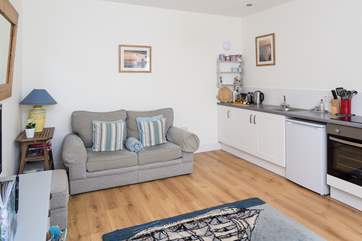 The open plan design of this cottage has plenty of comfortable space, the kitchen area is cleverly fitted along one wall.