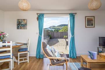 The cheerful open plan living-area opens onto the sunny patio, with wonderful views of Golden Cap!