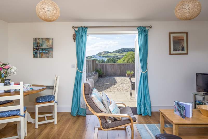 The cheerful open plan living-area opens onto the sunny patio, with wonderful views of Golden Cap!