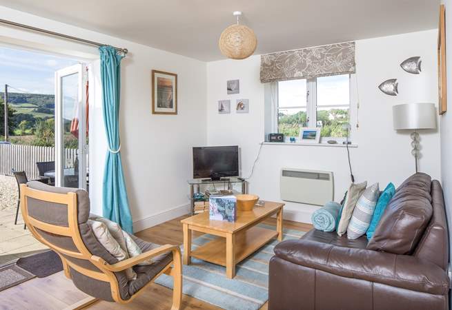 This welcoming open plan living-room has French doors straight out onto the enclosed patio. Please note, the patio furniture shown in the background here, has since been replaced with the wooden set, which can been seen in some of the other photographs.