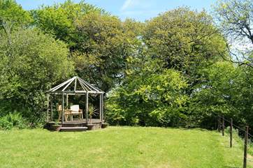 The garden and the pergola with its outdoor furniture.