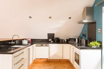 Black granite work surfaces set off the white units.