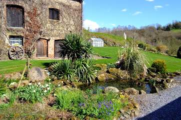 A storage barn is opposite the cottages and the grounds beyond.