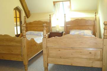 Bedroom 1 is light and airy, with these delightful wooden twin beds.