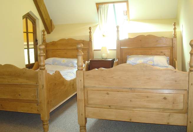 Bedroom 1 is light and airy, with these delightful wooden twin beds.