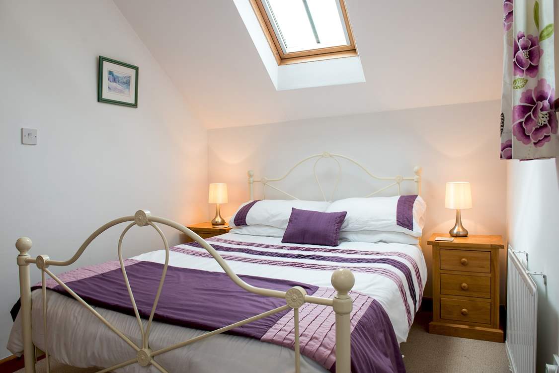 Both bedrooms have bright linens and lovely bedsteads.