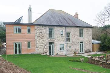 The 1970's extension has been cedar-clad and topped with thermal solar panels which produce masses of hot water backed up by a boiler system (picture taken during renovation; to be updated soon!).