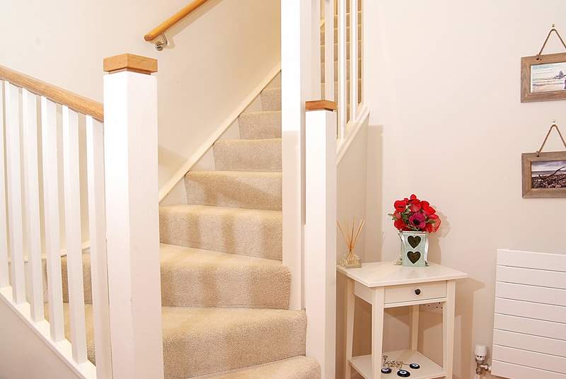 The apartment entrance hall on the ground floor with stairs leading to the open plan living-area on the first floor.