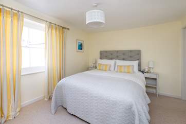 The master bedroom is beautifully designed with calm colours and a very comfortable bed. The en suite shower-room is to the right of the room.
