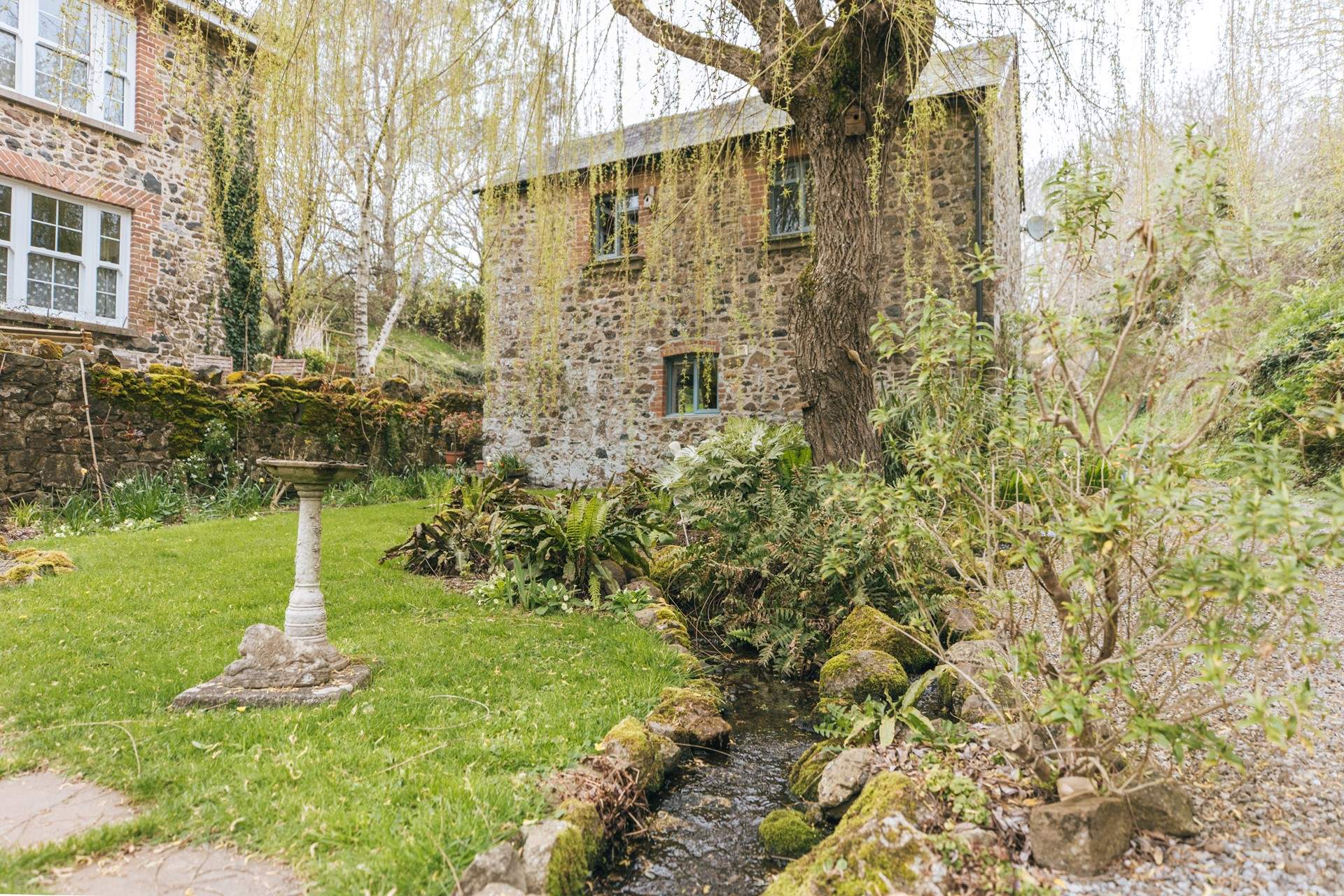 A pretty stream meanders in front of The Granary. The owners' home can be seen to the left.