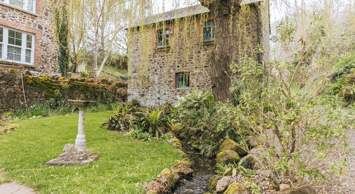 A pretty stream meanders in front of The Granary. The owners' home can be seen to the left.