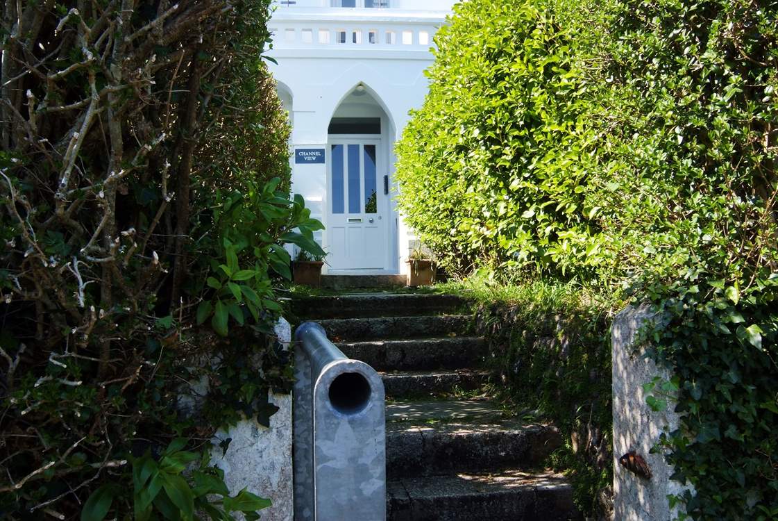 The rear door of the main building opens onto steps down to the coastal path.