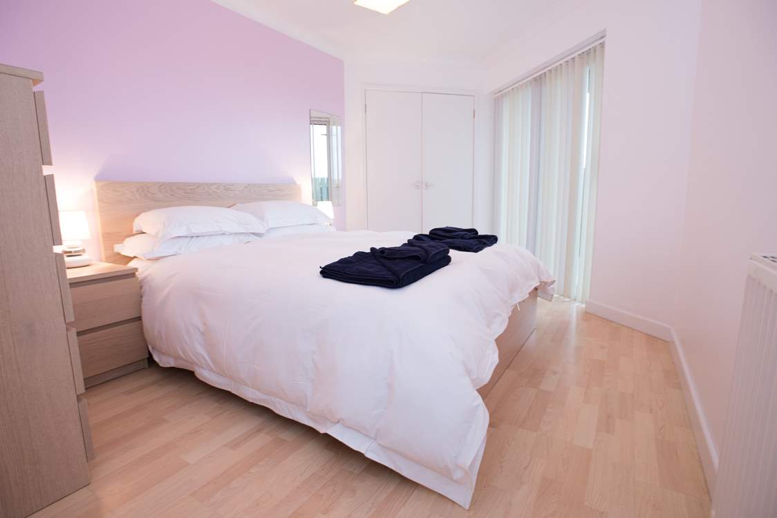 The ground floor en suite main bedroom has doors out to the decked terrace.