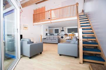 The first floor open plan living area has stairs up to the galleried bedroom.