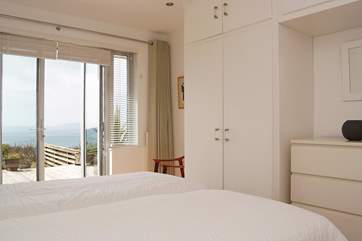 Lovely bedroom 1 has access to the decked terrace and sea views.