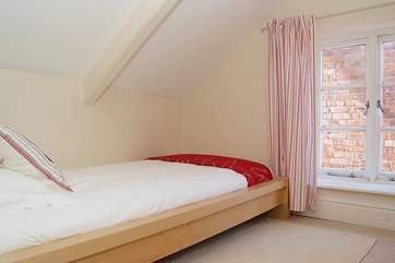 Bedroom 3 has sloping celings and a low-level bed.