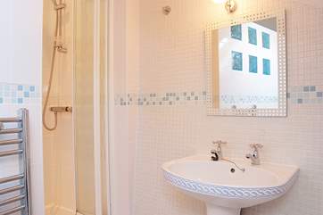 The shower cubicle is tucked into a corner.
